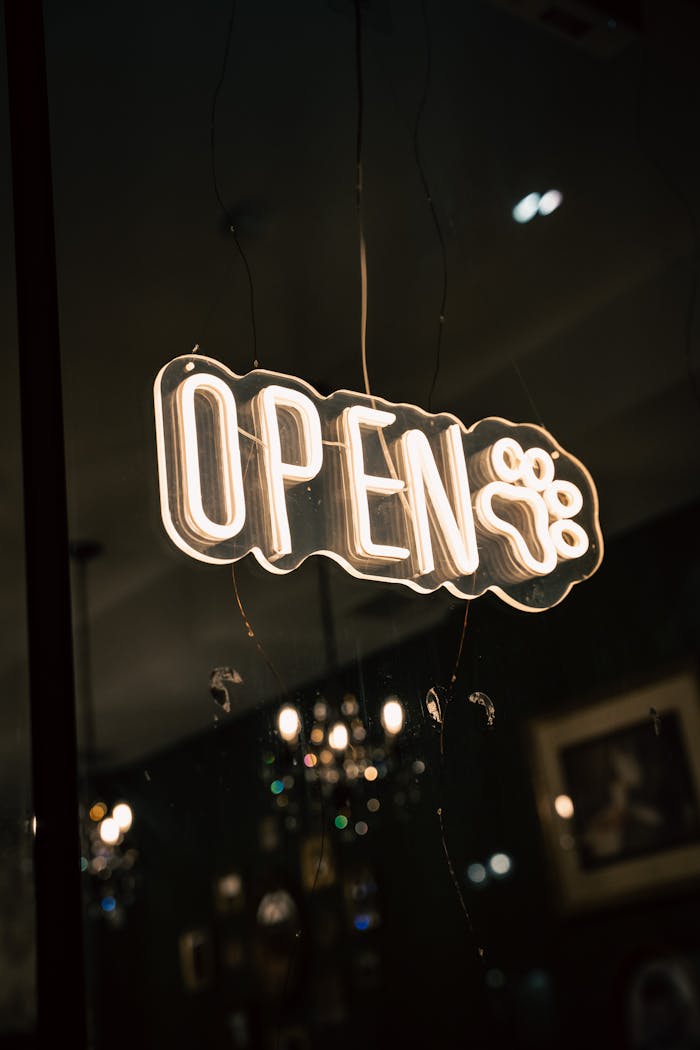 creative-01 A bright neon 'Open' sign illuminated indoors, creating a welcoming ambiance.