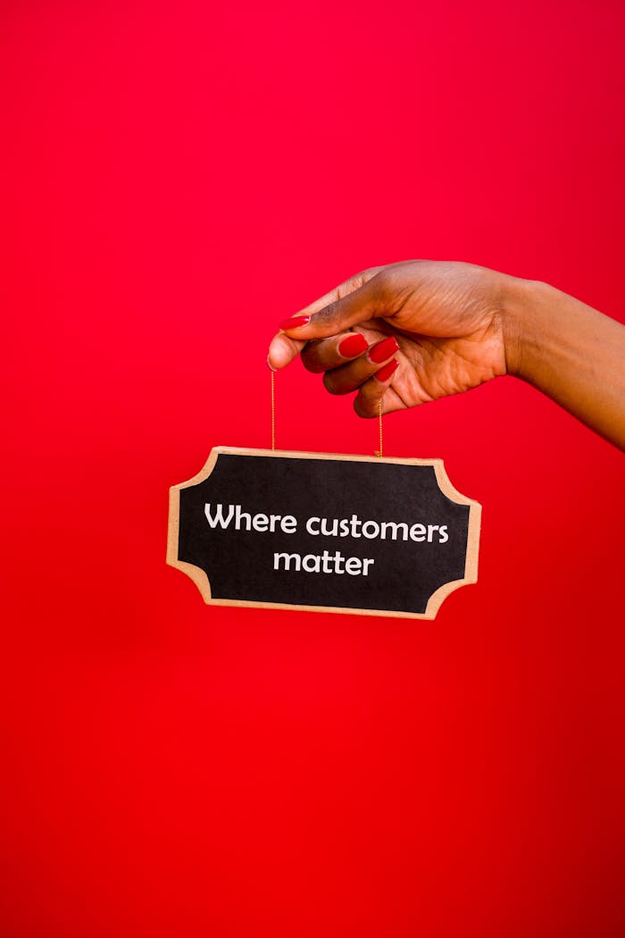brand-02 A hand holding a sign with the text 'Where customers matter' against a red background.