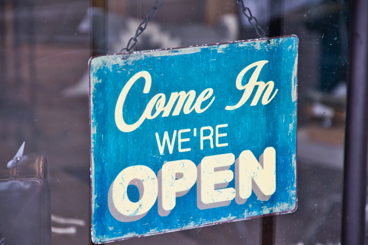 Mastering the First Impression: Your intriguing post title goes here Retro blue open sign on a shop glass door inviting customers in.